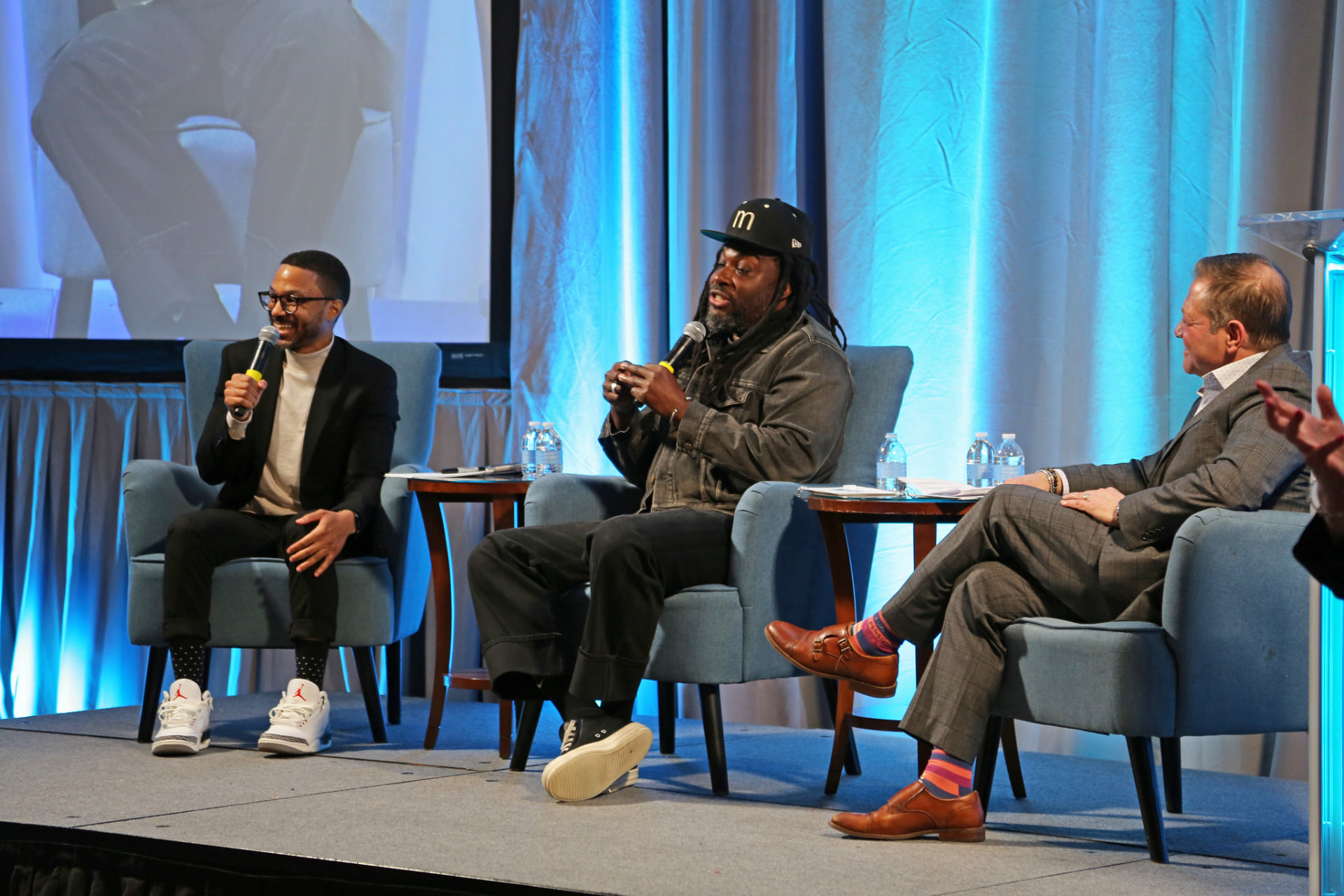 Aquaus Kelley laughing on stage during an NJEA panel